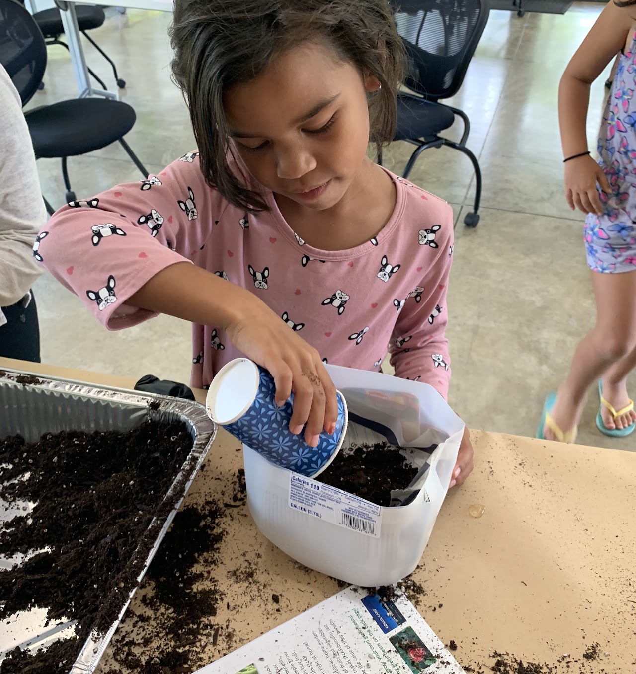 Student filling pot with soil