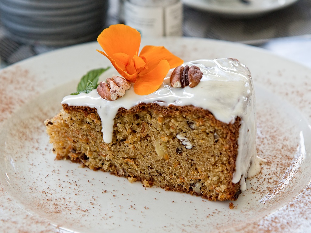 carrot cake topped with walnuts and a flower