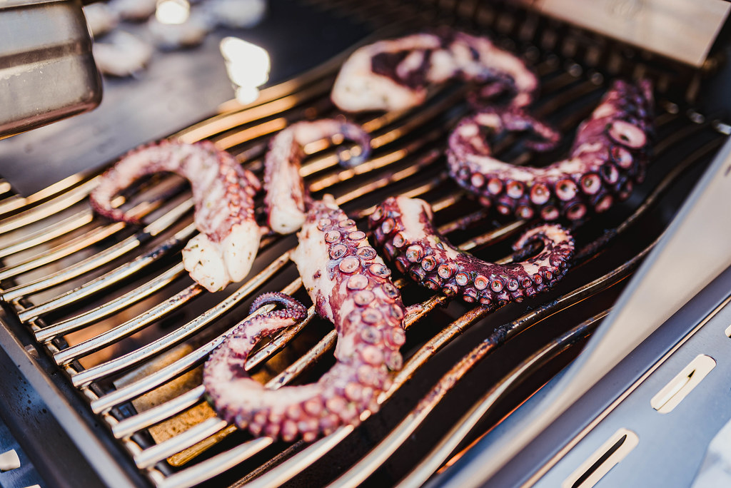 octopus tentacles being cooked on a grill