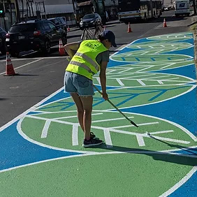 person painting leaf on parking lane of street
