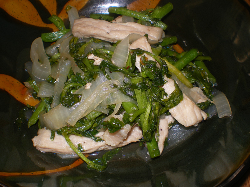 watercress and pork dish on a plate