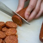 Pepperoni being sliced