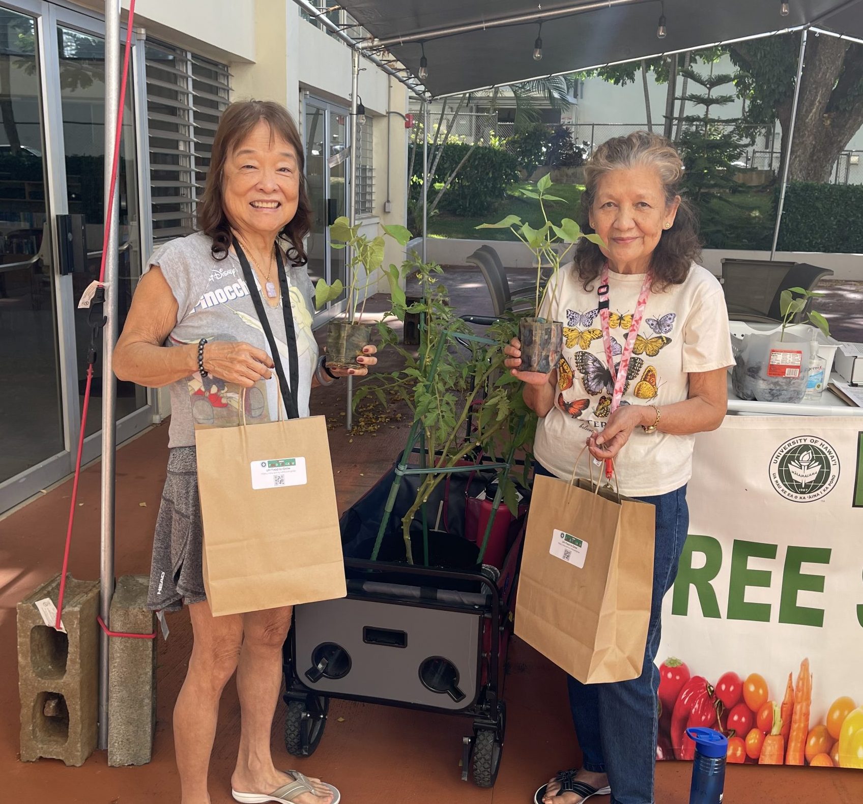 Two people holding green bean seedling kits