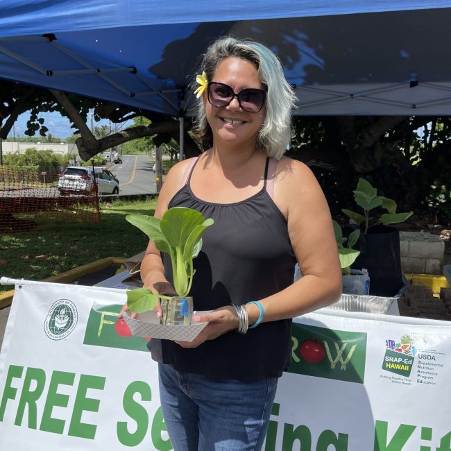 Participant posing with bok choy seedling kit