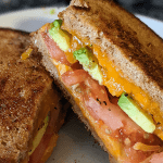 toasted grilled cheese sandwich with tomato and avocado slices