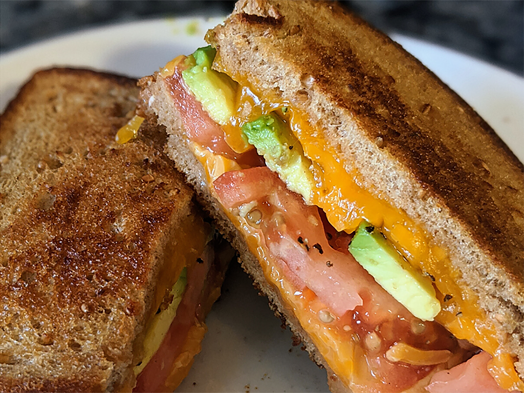 toasted grilled cheese sandwich with tomato and avocado slices