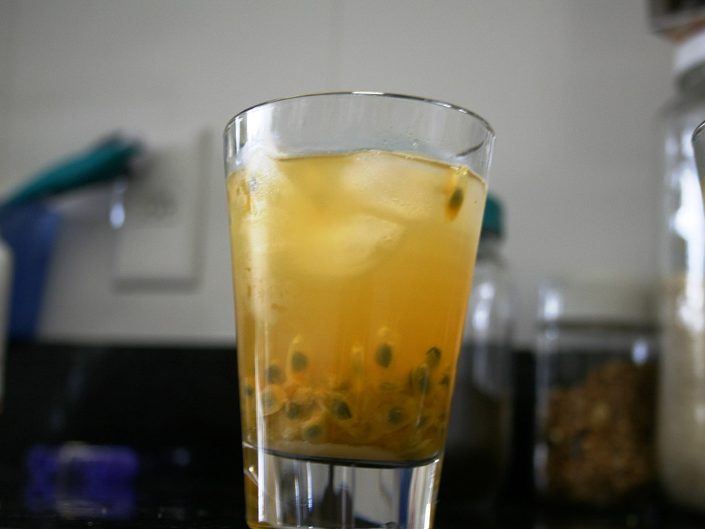 a glass of passionfruit juice with ice