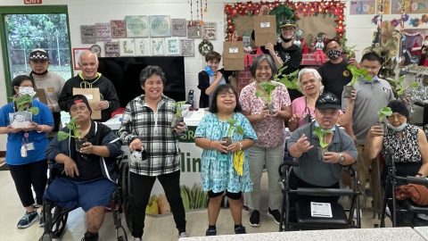 Participants posing with bok choy seedlings and kit bags