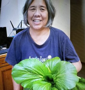 Participant posing with fully grown bok choy plant