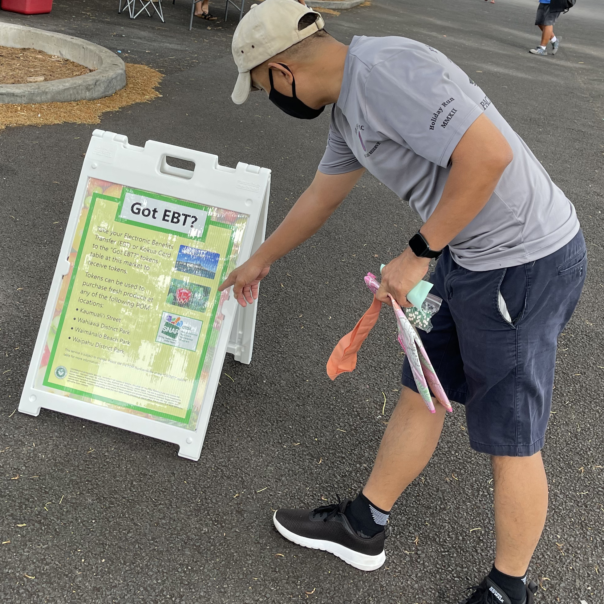 Person pointing to "Got EBT?" sign