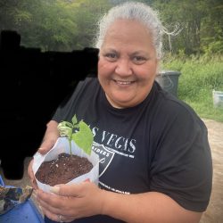 Participant posing with transplanted seedling