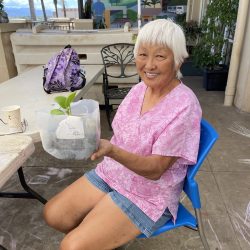 Participant poses with transplanted seedling