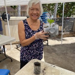 Participant poses with transplanted seedling