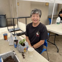 Participant poses with transplanted seedling