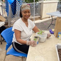 Participant poses with transplanted seedling