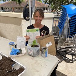 Participant poses with transplanted seedling