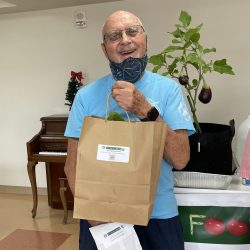 Participant posing with transplanted green bean seedling