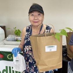 Participant posing with transplanted green bean seedling