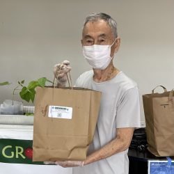 Participant posing with transplanted green bean seedling